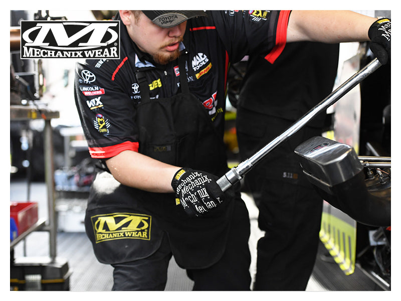 Mechanic wearing Mechanix Wear Original gloves while working on engine, ensuring safety and comfort in automotive repairs.
